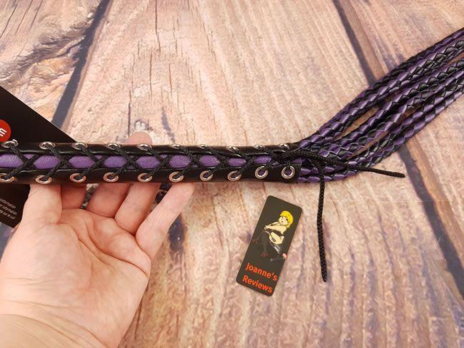 Image showing the handle of the cat o nine tails with my hand for scale