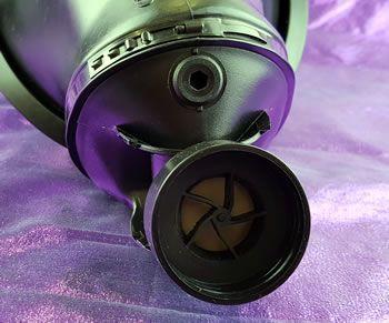 The air enters the gas mask through the valve at the bottom where a filter would be attached